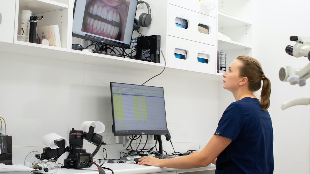 Female dentist looking at monitors