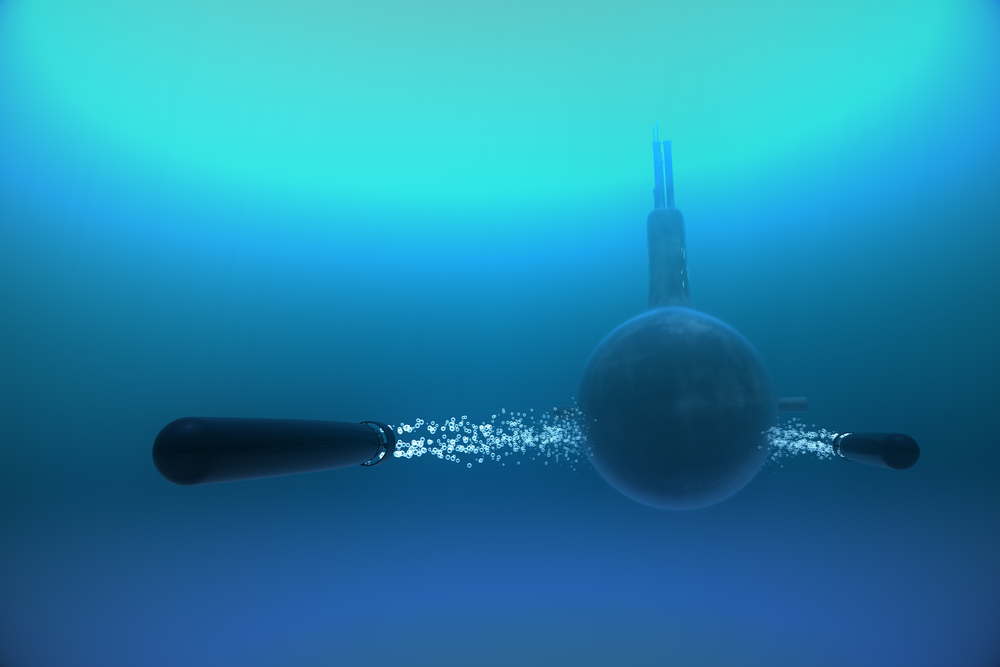 Submarine fires torpedo underwater.